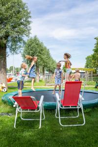 a group of children jumping on a trampoline at Woonboot de Waterwoning in Irnsum +3 photos