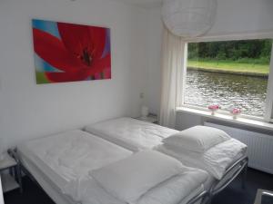 a room with two beds in front of a window at Woonboot de Waterwoning in Irnsum