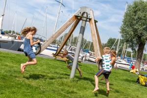 a group of children playing on a playground at Woonboot de Waterwoning in Irnsum