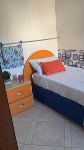 a bedroom with a bed with an orange headboard at Sea & spiagge a 200m Stella del Salento in Brindisi