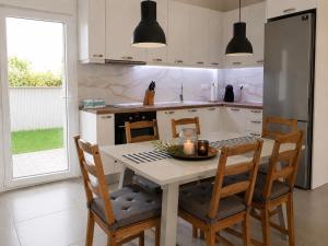 a kitchen with a table and chairs in a kitchen at Lagonisi Apartment in Skála Nikíta