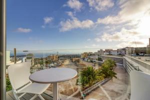 a balcony with a table and chairs and a view of the beach at Alse Homes Adeje in Adeje