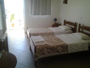 two beds in a hotel room with a window at Thalassa View Apartments in Diafani