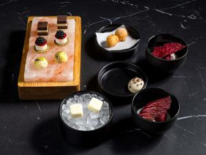a table topped with different types of cheese and desserts at Hotel Am Konzerthaus - MGallery Collection in Vienna