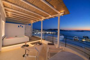 a balcony with chairs and a view of the ocean at Mykonos View Hotel in Mikonos
