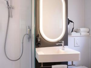 a bathroom with a sink and a mirror at Ibis Brussels City Centre in Brussels