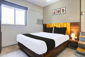 a bedroom with a large bed and a window at Hotel O Siba Inn in Mumbai