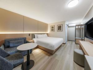 a hotel room with a bed and a table and chairs at Mercure Townsville in Townsville