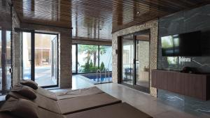 a living room with a couch and a flat screen tv at Palmen Villa Gabala in Gabala