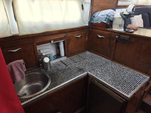 a small kitchen with a sink and a mirror at Bateau SKAMP in Mâcon