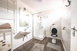 a white bathroom with a toilet and a sink at Gyarmati Vendégház Sirok in Sirok +57 photos