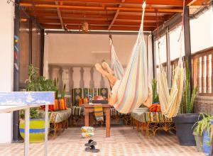 a patio with hammocks and a table and chairs at Surf hostel Morocco in Tamraght Ouzdar