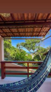a hammock on a balcony with a view of the ocean at Pousada Do Joe in Morro de São Paulo