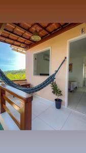 a hammock on the side of a house at Pousada Do Joe in Morro de São Paulo