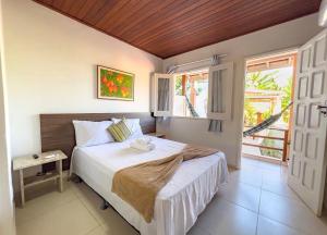 a bedroom with a large bed and a window at Pousada Do Joe in Morro de São Paulo