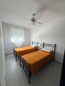 two beds in a room with a ceiling fan at DreamLiving Vasto Panorama in Vasto