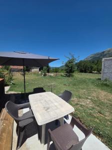 a table and chairs with an umbrella on a patio at Maki 4 in Radanovići