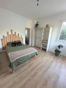a bedroom with a bed and a wooden floor at logement tranquille avec jardin in Saint-Germain-et-Mons