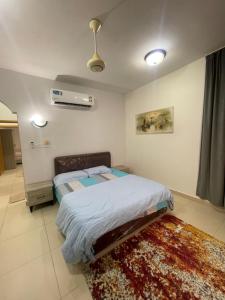 a bedroom with a bed and a rug on the floor at Adheeiz beach in Salalah