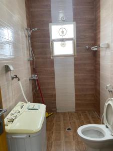 a bathroom with a toilet and a sink and a window at Adheeiz beach in Salalah