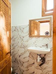 a bathroom with a sink and a mirror at Surf hostel Morocco in Tamraght Ouzdar +42 photos