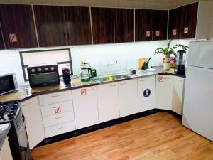a kitchen with white cabinets and a sink and a refrigerator at Cuba Linda Capsule Stay in Asunción