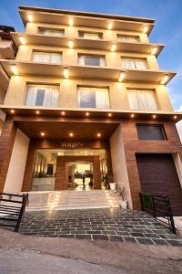 ein großes Gebäude mit einer Treppe davor in der Unterkunft Tata Vista By Vaikunth - McLeod Ganj-Centrally Heated & Air Cooled # Near Mall Road # Big Parking # Lift #Spacious Rooms # Most Awarded # Property Of The Year # in Dharamshala