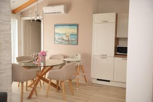 a kitchen and dining room with a table and chairs at Apartments & Villa Tisno in Obrovac