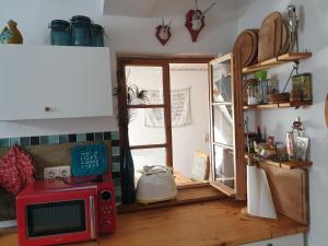 a kitchen with a red microwave and a window at Unser Obervolkacher Ferienhaus - Hideaway & Gartenoase mit Wohlfühlflair und Herz für Hunde in Volkach +29 photos