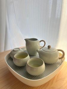a tray with three tea sets on a table at mini嵐輕旅 in Guanyin
