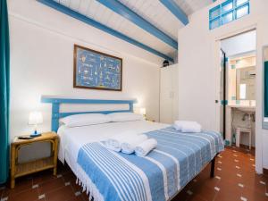 a bedroom with a blue and white bed with towels on it at Sweet home Santa Lucia in Santa Lucia