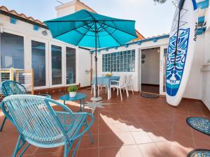 a patio with a table and chairs and a surfboard at Sweet home Santa Lucia in Santa Lucia