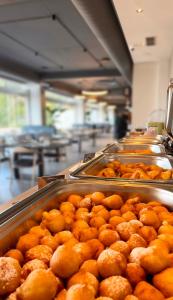 a bunch of donuts on trays in a bakery at White Amfora Hotel in Shëngjin +17 photos