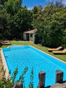 a blue swimming pool in a yard with trees at lov nid in Apt