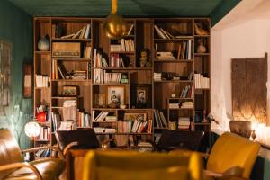 a library with wooden shelves filled with books at Sel d Ailleurs, Ouirgan - adults only in Ouirgane