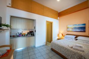 a bedroom with a large bed and a kitchen at Sogno Blu in Furore