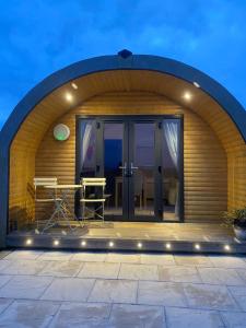 an arched patio with a table on a deck at Braehead Pods in Forth +3 photos