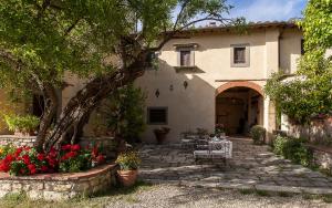 a house with a patio and flowers in front of it at Villa Il Paradisino in Sesto Fiorentino
