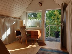 an attic room with a desk and a window at Unser Obervolkacher Ferienhaus - Hideaway & Gartenoase mit Wohlfühlflair und Herz für Hunde in Volkach