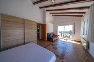 a bedroom with a bed and a couch and a window at Villa Panoramic in Santa Susanna +45 photos