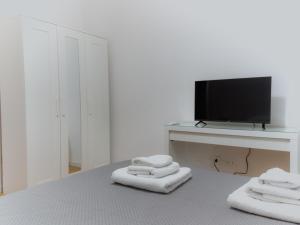 a bedroom with towels on a bed with a television at Mara's home in San Salvo