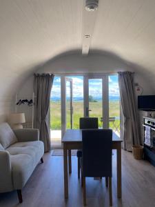 a living room with a table and a couch at Braehead Pods in Forth