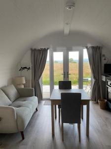 a living room with a table and a couch at Braehead Pods in Forth