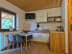 a kitchen with a table and chairs in a room at Leśny Dwór Bieszczady in Ustrzyki Dolne