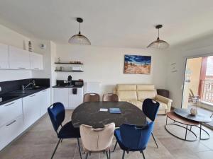 a kitchen and dining room with a table and chairs at La Perle bleue in Berck-sur-Mer