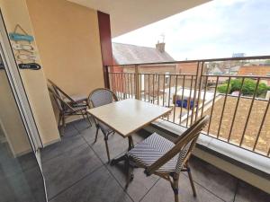 a balcony with a table and chairs and a view at La Perle bleue in Berck-sur-Mer