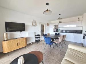 a living room with a dining table and a kitchen at La Perle bleue in Berck-sur-Mer