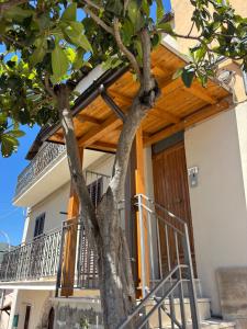 a house with a wooden door and a tree at Il Nespolo in Celano +2 photos
