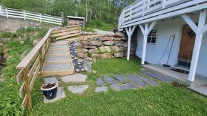 a yard with a stone wall and a house at Leilighet på Bekkeli, Beito. in Beitostøl
