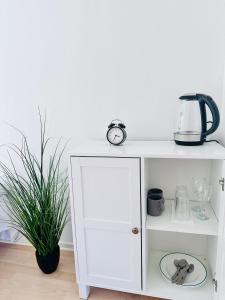 a white cabinet with a clock on top of it at Systrarna på Kivik in Kivik